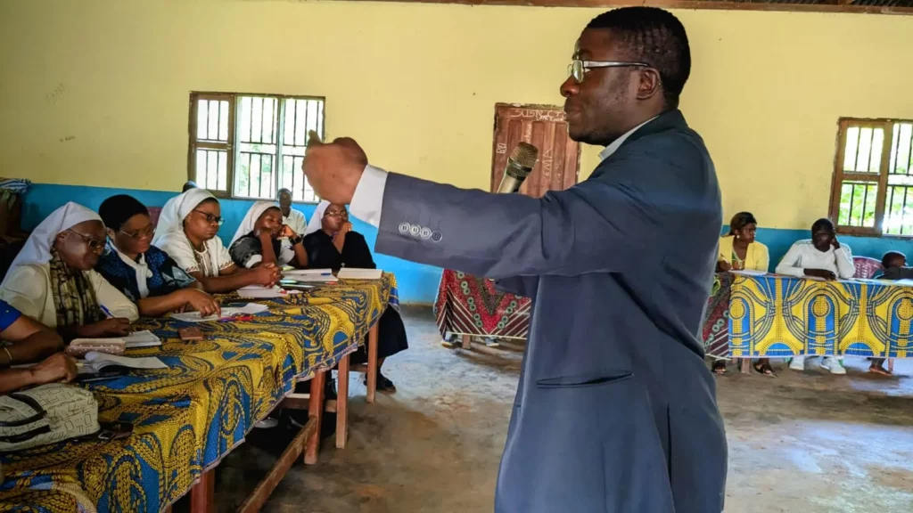 Image du père Antoine Thierry EDANG coach certifié en PNL dispensant une formation dans une salle pleine